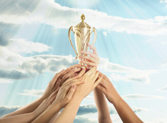Wall Mural - woman holding golden trophy and people reaching for it against sky