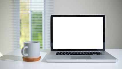 Fototapete - Modern home office setup featuring a blank laptop screen and a gray coffee cup, perfect for presentations or mockups.