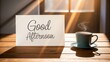 © Ilmi - A handwritten 'Good Afternoon' message with a cup of tea or coffee beside it, on a cozy wooden table with sunlight filtering through the window