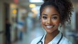 © Lina - A confident female doctor with a stethoscope smiles in a hospital corridor.
