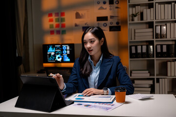 Aufkleber - Asian businesswoman working late using tablet and analyzing financial charts in office