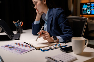 Aufkleber - Asian businesswoman working late and taking notes in her notebook