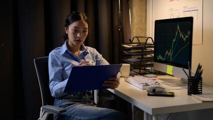 Poster - Businesswoman analyzing financial charts and taking notes in office at night