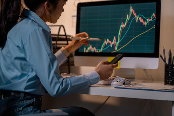 Poster - Businesswoman analyzing financial chart on computer screen and holding smartphone