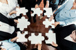 © InfiniteFlow - Top view multiethnic business people holding jigsaw pieces and merge them together as effective solution solving teamwork, shared vision and common goal combining diverse talent. Meticulous