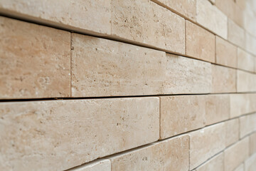 Aufkleber - Close-up view of a textured beige wall, featuring a pattern of stacked rectangular blocks with visible pores and subtle color variations. Architectural detail.