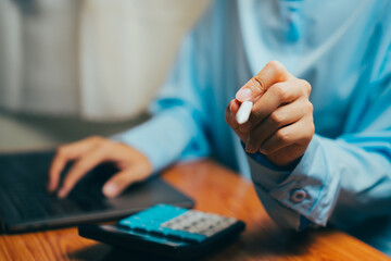 Poster - Person Holding White Chalk While Using Laptop and Calculator on Wooden Table, Business concept.