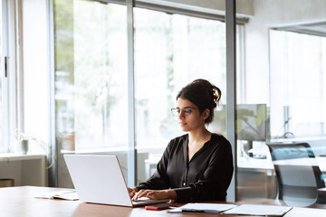 young professional it specialist latin hispanic business lady working on laptop pc sitting at desk i