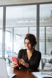 © Stock 4 You - Focused Latin Hispanic female businesswoman holding smartphone sitting at desk in office. Vertical portrait successful business woman manager ceo using cell phone mobile pc for online working or call