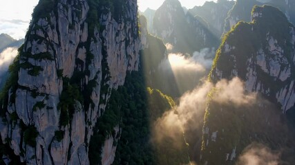 Aufkleber - Sunlit mountain cliffs with misty valleys at dawn, nature exploration concept