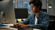 © Postmodern Studio - Asian teen boy focused on computer work in office environment