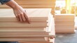 © pattaphorn - Person Checking Quality of Wooden Planks in Workshop Environment with Sunlight Casting a Warm Glow