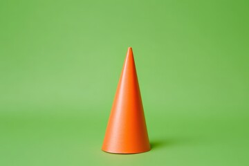 Fototapete - A single orange cone stands prominently against the green background