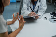 © Phimwilai - Female doctor taking notes while listening to patient describing symptoms