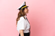 © luismolinero - Airplane middle aged pilot woman isolated on pink background laughing in lateral position