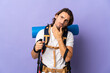 © luismolinero - Young mountaineer man with a big backpack over isolated background having doubts
