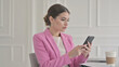 © Dream Vision - Businesswoman in pink blazer using smartphone in modern office
