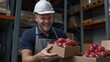 © Akkord27 - Warehouse worker smiling while handling packed goods during busy shift