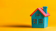 © Vivi - Teal Miniature House Model on Yellow Background