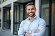 © NeedMoreMars - Confident Young Caucasian Adult Male Smiling in Business Attire Outside Modern Office Building, Showcasing Professionalism and Charisma in a Bright Environment