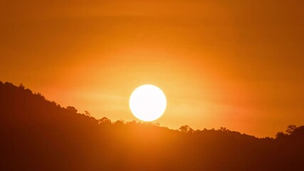Wall Mural - breathtaking beauty of the sun rising time lapse video over a rugged mountain ridge on a cloudy morn