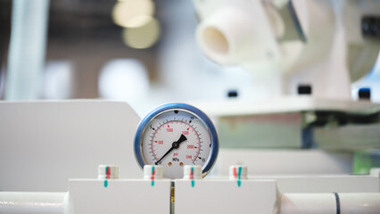 Aufkleber - A white and blue pressure gauge sits on a white surface. The gauge is marked with numbers and a clock face. Concept of precision and accuracy