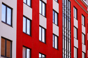 Aufkleber - A modern apartment building with numerous windows and a red and white exterior.