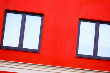 Aufkleber - A small red building with two windows and a clock on the front, suitable for use in illustrations about time or architecture.