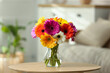 © New Africa - Bouquet of beautiful gerbera flowers in glass vase on wooden table indoors