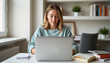 © Tatiana - Focused woman studying online in cozy home office, learning environment