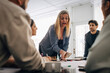 © Maskot - Mature businesswoman explaining strategy to male and female colleagues during meeting in office