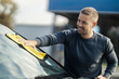 © Dusan Petkovic - A man is polishing windshield on a car with microfiber cloth at car wash.