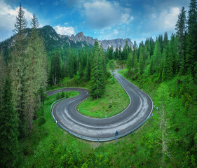 Wall Mural - aerial view of curvy road and green forest in alpine mountains in summer. dolomites, italy. top view