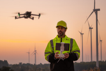 Aufkleber - Engineers male flying drone surveying and checking wind turbines from the high angle view of the field during beautiful sunset. using drone technology for work.