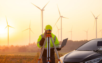 Aufkleber - Engineer working on laptop in front of wind turbines for checking wind turbines of the field during beautiful sunset. Alternative energy concept.