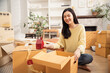 © winnievinzence - Asian smiling woman with packing cardboard boxes for moving to the new home. Concept of people moving house, buying property and decorating room