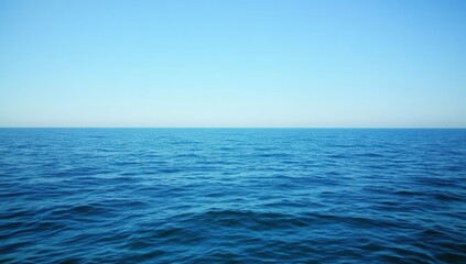 Poster - Calm and Serene Ocean View Under Clear Blue Sky with Gentle Waves Rippling Across the Water Surface in Peaceful Coastal Landscape
