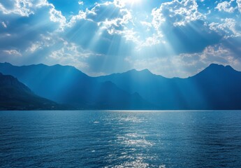 Poster - Serene Ocean Landscape with Rays of Sunlight Illuminating the Water and Mountains Under a Dramatic Cloudy Sky