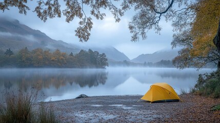 Aufkleber - A yellow camping tent beside a misty lakeside, framed by autumn trees and mountains in the distance, capturing the beauty of nature during a foggy morning