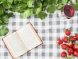 © InkCrafts - A serene picnic setup with a book, strawberries, and a glass of drink on a checkered blanket.