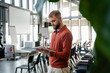 © Westend61 - Young man using a tablet in a modern office setting