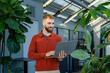 © Westend61 - Young man working on a laptop in a green office environment