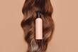 © Westend61 - Shampoo bottle on curly brunette hair with brown background