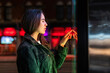 © Westend61 - Woman interacting with a bright screen at night in an urban setting