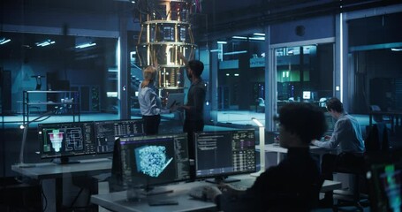 Female and Male Engineers Working in an Advanced Lab. Technician and Manager Discussing Quantum Computing Technology, Software Developers Programming and Monitoring Data on Computer Screens