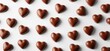 © Vergiliy - Chocolate heart-shaped candies arranged in a beautiful pattern on white background