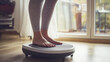 © Sajib - Woman using a vibration plate for fitness at home healthy lifestyle loss body slim gray legs feet