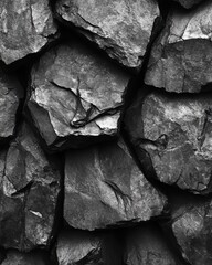 Poster - Monochromatic stone texture with deep shadows and rugged surface creating a natural organic pattern for backgrounds