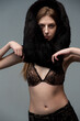 © alipko - Elegant young woman in black lace lingerie with a luxurious fur wrap, posing confidently in a studio setting. Fashionable, sensual, and sophisticated look with soft lighting