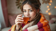 © hurricanehank - Young female treats cold with hot drink. Cute girl drinking herbal tea covered with blanket at home.